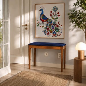 Peut inclure: Un banc rectangulaire en bois avec une assise rembourrée bleu foncé, placé contre un mur gris clair. Au-dessus du banc est accrochée une impression carrée encadrée représentant un paon stylisé aux motifs circulaires rouges, bleus et verts.