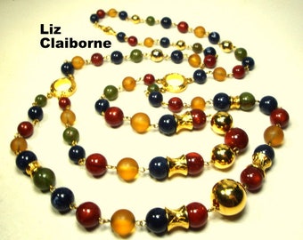 May include: A long multi-strand necklace with gold, amber, red, green, and blue beads. The necklace is made by Liz Claiborne.