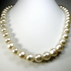 May include: A white pearl necklace with a classic design. The pearls are evenly spaced and have a smooth, lustrous finish.