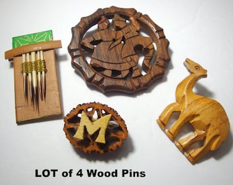 May include: A collection of four wooden pins. Includes a carved wooden figure, a pin with the letter "M", a pin with a figure in a circle, and a pin with a wooden container with quills. The text "LOT of 4 Wood Pins" is at the bottom.