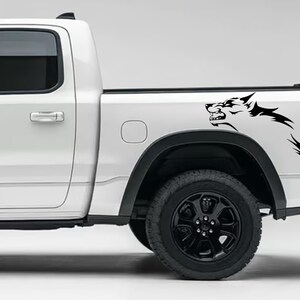 May include: White pickup truck with a black wolf decal on the side of the load bed.
