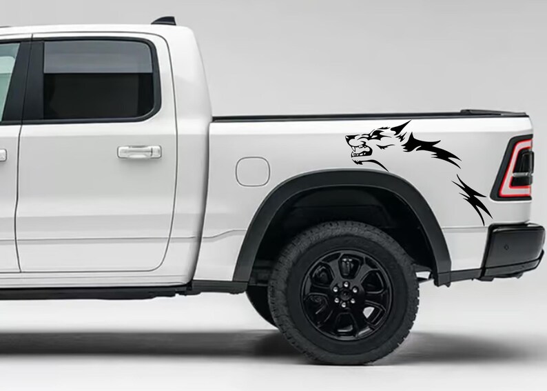 May include: White pickup truck with a black wolf decal on the side of the load bed.