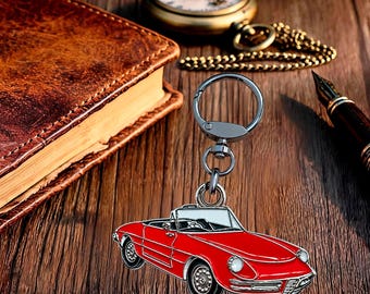 May include: A metal keychain featuring a red convertible sports car charm with a silver-toned split ring and lobster clasp attachment. The car design includes black wheels, a white windshield, and detailed silver trim along the body and headlights.