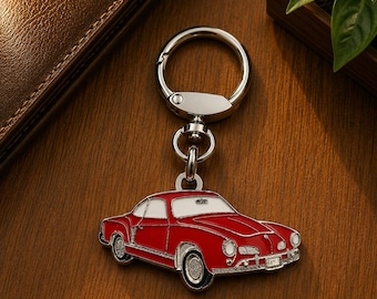 May include: A silver-toned metal keychain featuring a red and white enamel charm shaped like a vintage sports car. The charm is attached to a circular split ring by a small swivel connector, showcasing detailed lines on the car body and wheels.
