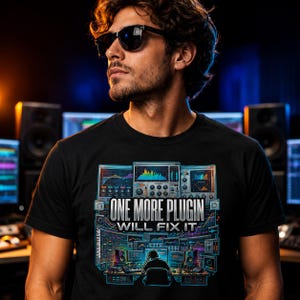 May include: Black t-shirt with a colorful graphic of audio equipment and the text "ONE MORE PLUGIN WILL FIX IT." The design includes a person at a mixing console. The person is wearing sunglasses.
