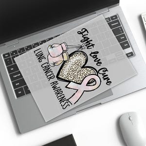 a laptop with a printed design on the screen, which includes a heart and a pink ribbon symbolizing lung cancer awareness.