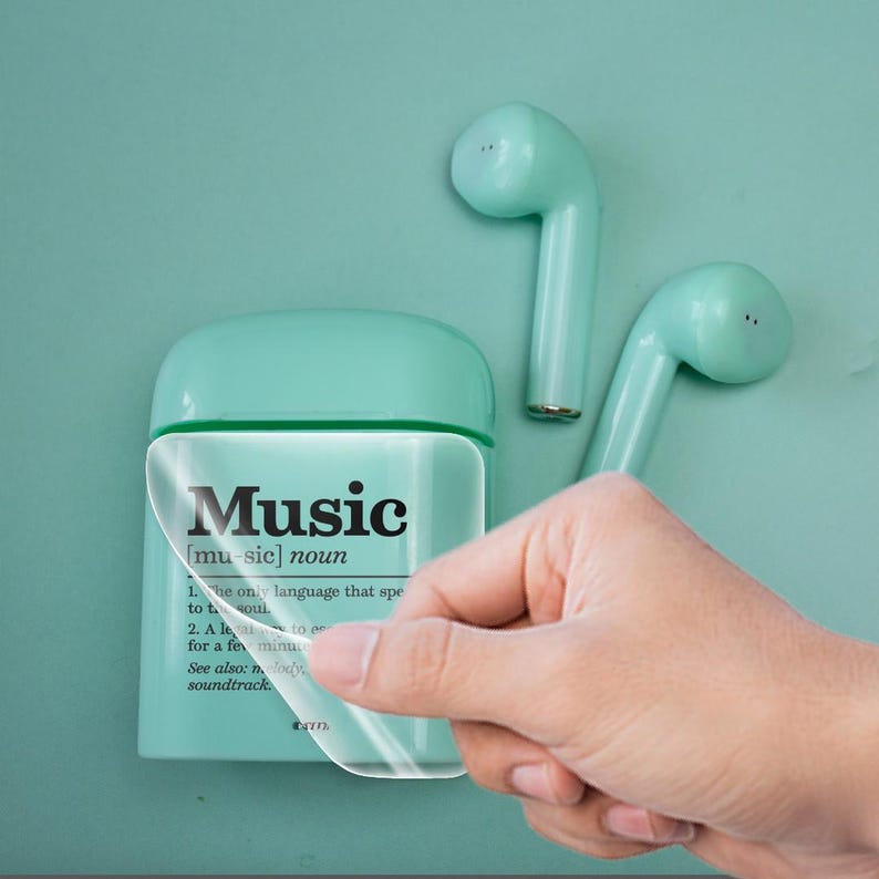 May include: A mint green wireless charging case for earbuds with a clear sticker on the front that says "Music [music] noun 1. The only language that speaks to your soul. 2. A  listen to for a few minutes."