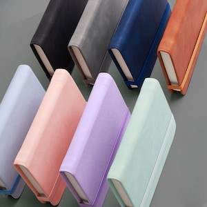 以下が含まれることがあります： 薄い青、ピンク、ラベンダー、ミントグリーン、グレー、ブラック、ネイビーブルー、オレンジなど、さまざまな色のノートブック8冊のセット。各ノートブックには、ゴムバンドの留め具が付いています。