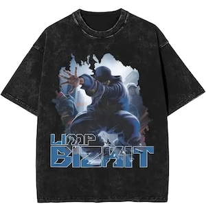 May include: Black t-shirt with a graphic of a person in a blue outfit, with the text "LIMP BIZKIT" in blue and white. The shirt has a vintage, washed look.
