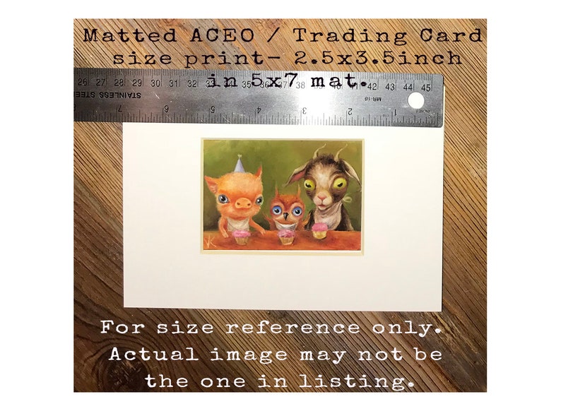 May include: A matted print of a whimsical illustration featuring a pig, an owl, and a goat wearing party hats and holding cupcakes. The print is 2.5 inches by 3.5 inches and is matted to a size of 3.5 inches by 7 inches. The text "For size reference only. Actual image may not be the one in listing." is printed below the illustration.