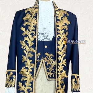 K&ouml;nnte beinhalten: Ein marineblauer Festanzug mit goldgestickten floralen Designs. Der Anzug besteht aus einem langen Mantel, einer Weste und Shorts. Der Mantel hat goldene Verzierungen und Manschetten, und die Weste hat einen wei&szlig;en Spitzeneinsatz. Der Anzug wird auf einer Schaufensterpuppe pr&auml;sentiert.