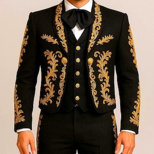 Puede incluir: Un traje de mariachi negro con bordados dorados, un chaleco a juego y un gran sombrero. El traje presenta patrones florales dorados ornamentados y botones dorados. El conjunto incluye una camisa blanca y una pajarita negra.