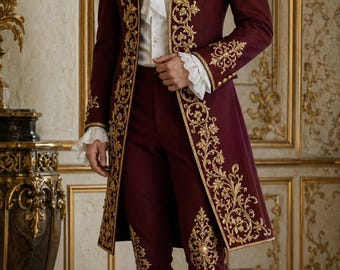 Pode incluir: Terno formal bordô com bordados dourados. O conjunto inclui um casaco comprido, calças curtas e uma camisa branca com babados. A roupa é completada com sapatos pretos e meias brancas, de estilo histórico.