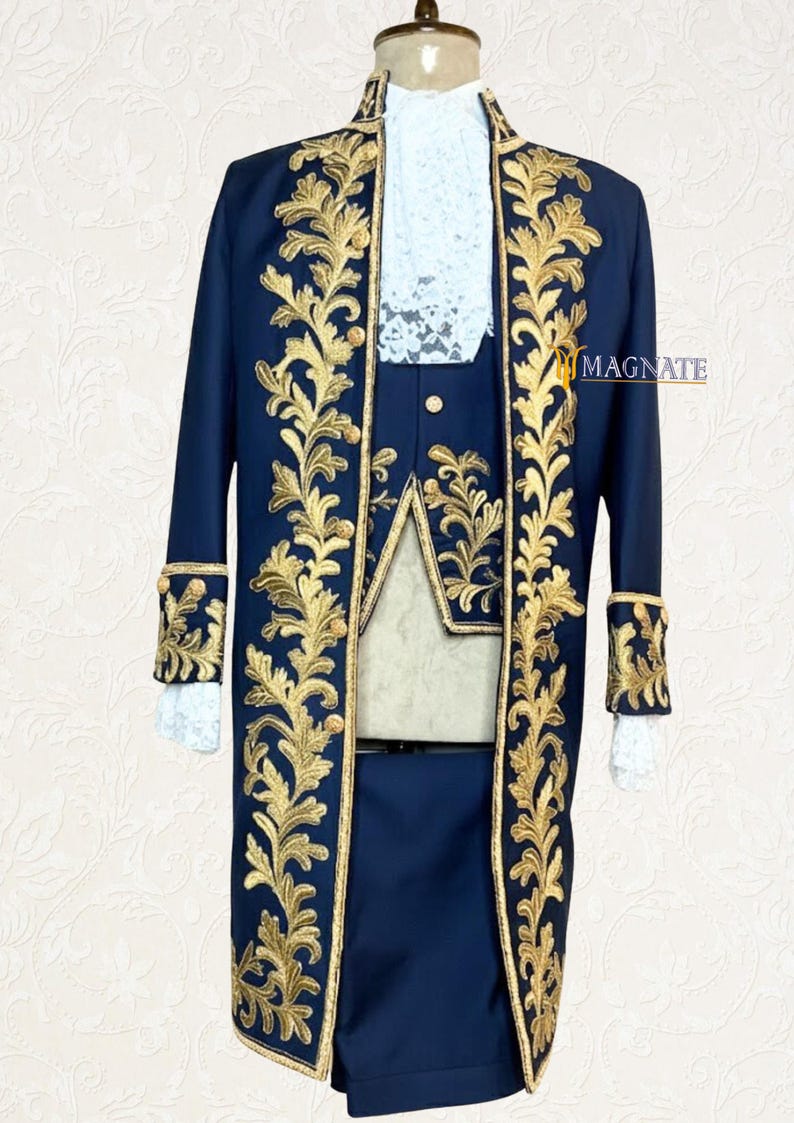 K&ouml;nnte beinhalten: Ein marineblauer Festanzug mit goldgestickten floralen Designs. Der Anzug besteht aus einem langen Mantel, einer Weste und Shorts. Der Mantel hat goldene Verzierungen und Manschetten, und die Weste hat einen wei&szlig;en Spitzeneinsatz. Der Anzug wird auf einer Schaufensterpuppe pr&auml;sentiert.