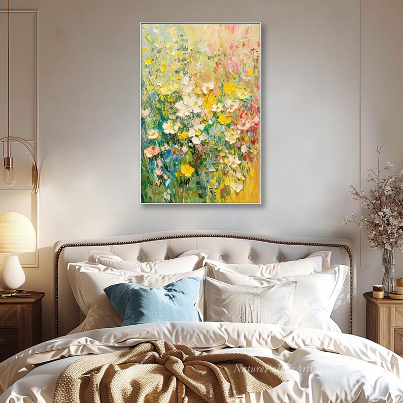 May include: A framed floral oil painting with a vibrant display of yellow, white, and pink flowers. The artwork features a textured impasto style, with visible brushstrokes creating depth and movement. The painting is set against a soft yellow and green background.
