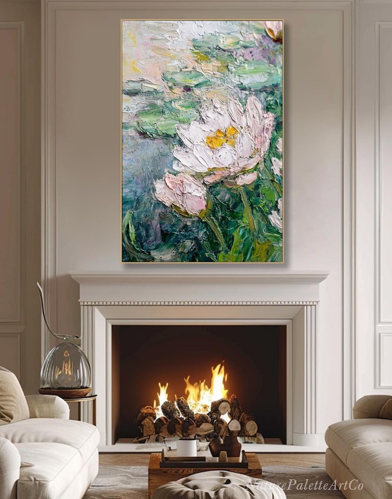 May include: An impressionistic oil painting of water lilies in a pond. The artwork features large, textured brushstrokes in shades of pink, white, green, and yellow. The painting is framed in a gold-colored frame and hangs above a fireplace.