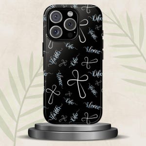 May include: A black smartphone case featuring a repeating pattern of white line-art crosses and the words Faith, Hope, and Life written in a cursive script. The design covers the entire back of the case, including the area around the camera lens.