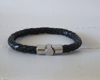 May include: A black leather bracelet with a silver magnetic clasp.