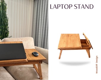May include: A wooden laptop stand with a fold-out drawer. The stand is made of natural wood and has a simple, modern design. It is perfect for working from home or on the go.