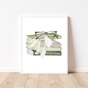 Puede incluir: Una pila de libros verdes y blancos con un par de gafas marrones encima. Una cinta blanca está atada alrededor de los libros.