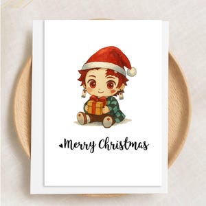 May include: A white greeting card with a cartoon character wearing a Santa hat and holding a gift. The character has red hair and is wearing a green and black checkered robe. The words "Merry Christmas" are written in black script.