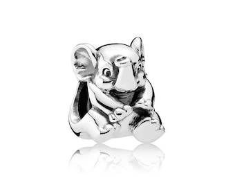May include: A silver elephant charm in a sitting position. The charm features large ears, a trunk, and is holding something in its front legs. The polished surface reflects light, giving it a bright appearance. The charm is likely for a bracelet or necklace.