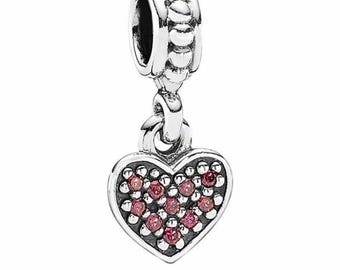 May include: A silver charm with a heart-shaped pendant. The heart is outlined with a dark border and filled with small pink gemstones. The charm has a beaded top and a loop for attaching to a bracelet or necklace.