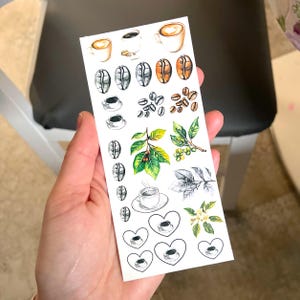 May include: A sheet of white sticker paper with various coffee-themed illustrations. The stickers feature coffee beans, coffee cups, coffee plants, and hearts.