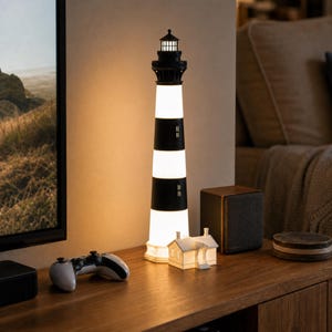 K&ouml;nnte beinhalten: Eine hohe, zylindrische Leuchtturmlampe mit abwechselnden horizontalen schwarzen und wei&szlig;en Streifen. Die Struktur ist mit einer schwarzen Laterne und einem leuchtenden Licht versehen. Ein kleines, wei&szlig;es, hausf&ouml;rmiges Objekt steht am Fu&szlig;.