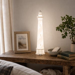 May include: A tall, cylindrical lighthouse lamp featuring a white and off-white spiral striped pattern. The structure includes a detailed lantern room at the top, small rectangular windows along the body, and a base with a small door entrance.