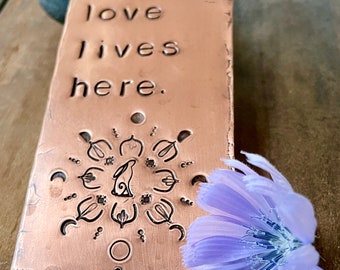 Love lives here, targa in rame caldo, orientamento verticale