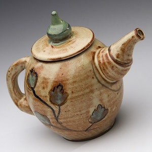 Handmade pottery teapot with painted leaves