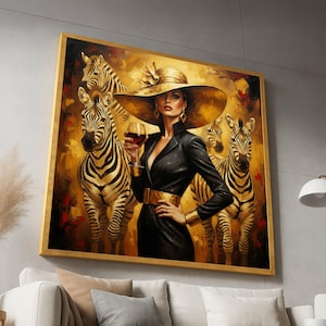 May include: A framed artwork shows a woman in a black outfit and large hat, holding a wine glass, with zebras in the background. The painting has a gold and brown colour palette, with a gold frame. The woman is wearing gold jewellery and a gold belt.