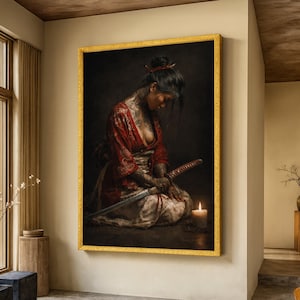 May include: A framed artwork depicts a woman in a red kimono with intricate tattoos, holding a katana sword. A lit candle sits nearby, casting a warm glow. The artwork is set against a dark background, framed in gold.
