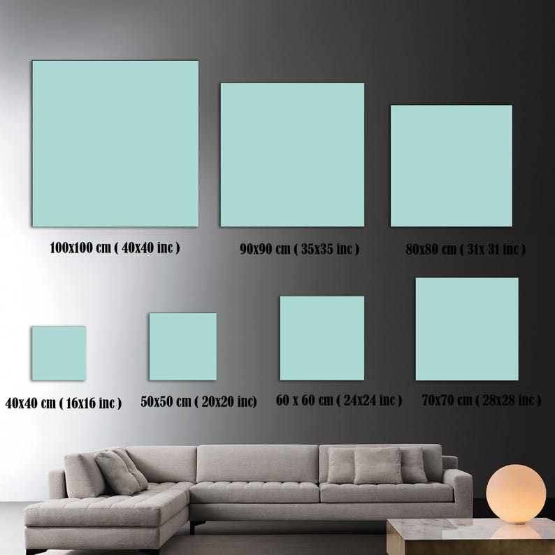 Pu&ograve; includere: Un confronto tra diverse dimensioni di tele quadrate di colore azzurro chiaro, che vanno dai 40 cm ai 100 cm. Le tele sono esposte su una parete grigia con un divano grigio e un tavolino in primo piano.