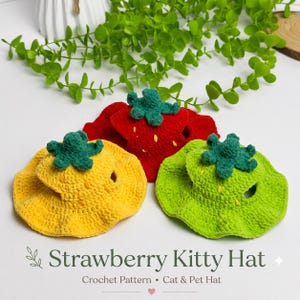 Puede incluir: Tres sombreros de ganchillo para mascotas en rojo, amarillo y verde claro, cada uno con forma de fresa con un tallo verde en la parte superior y pequeños detalles de semillas bordados en amarillo o blanco. Los sombreros tienen ala ancha y orificios.