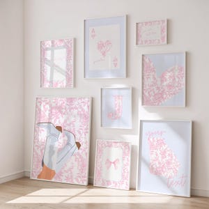 May include: A collection of framed art prints in various sizes, featuring a consistent pink and white color scheme. The prints showcase floral patterns, playing card designs, a bow, and the letter "J". Some prints include text, such as "your text".