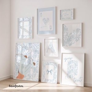 May include: A collection of framed art prints in various sizes, featuring a consistent light blue and white color scheme. The prints include floral patterns, playing card designs, and text elements. The overall aesthetic is soft and decorative.