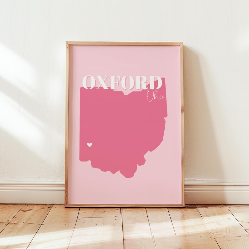 Op de afbeelding: Roze en witte print met het woord "Oxford" en de staat Ohio, die in roze is omlijnd. Een klein wit hartje bevindt zich in het midden van de staat.