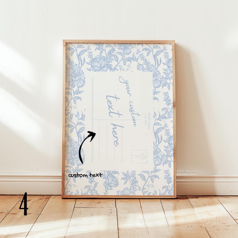 May include: A framed print featuring a floral design in light blue on a cream background. The print has a postcard layout with space for custom text. The frame is made of light-colored wood. The words "your custom text here" are visible.