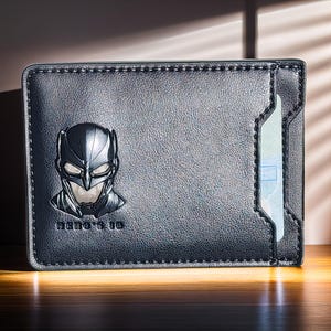 May include: Black leather wallet with a Batman logo and a clear plastic card holder. The wallet has a stitched edge and the text "HERO'S ID" is printed on the front.