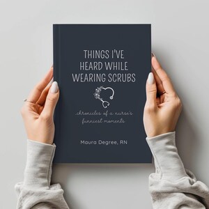 Op de afbeelding: Een marineblauw boek met de titel "THINGS I'VE HEARD WHILE WEARING SCRUBS" met een bloemig stethoscoop-afbeelding. Het boek wordt door twee handen vastgehouden. De tekst hieronder luidt "chronicles of a nurse's funniest moments" en "Maura Degree, RN".