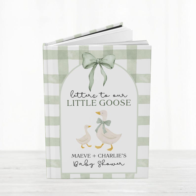 May include: A baby shower guest book with a green gingham pattern cover. The cover features a watercolor illustration of two geese and the text "Letters to our Little Goose". The book is open, revealing blank pages.