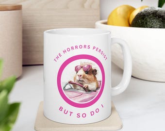 Taza de café con meme divertido "Los horrores persisten, pero yo también". Regalo único para amantes del café. Taza de humor negro.