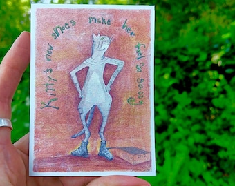 May include: A hand-drawn illustration on a small card featuring a cat wearing boots. The cat is standing with its hands on its hips. The text around the cat reads "Kitty's new shoes make her feel so sorry."