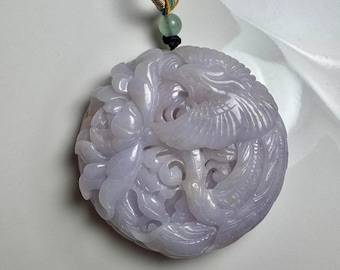 May include: A lavender jade pendant carved with a bird and floral design. The pendant is round and has a detailed, intricate design.