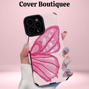 May include: A phone case with a pink butterfly wing design. The case has a light pink background with vertical lines. The butterfly wing is a watercolor style with shades of pink and white. The text "Cover Boutiquee" is at the top.