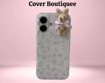 May include: Clear phone case with a floral pattern and a plush bunny with a pink and white gingham bow. The text "Cover Boutiquee" is at the top of the image.