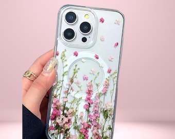 May include: Clear phone case with a floral design featuring pink and white flowers. The case has a magnetic ring and the text "Cover Boutiquee" at the top.