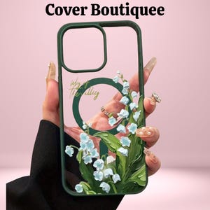 May include: A clear phone case with a green border and a floral design featuring light blue flowers and green leaves. The case has the text "Way of the Valley" and "Cover Boutiquee".
